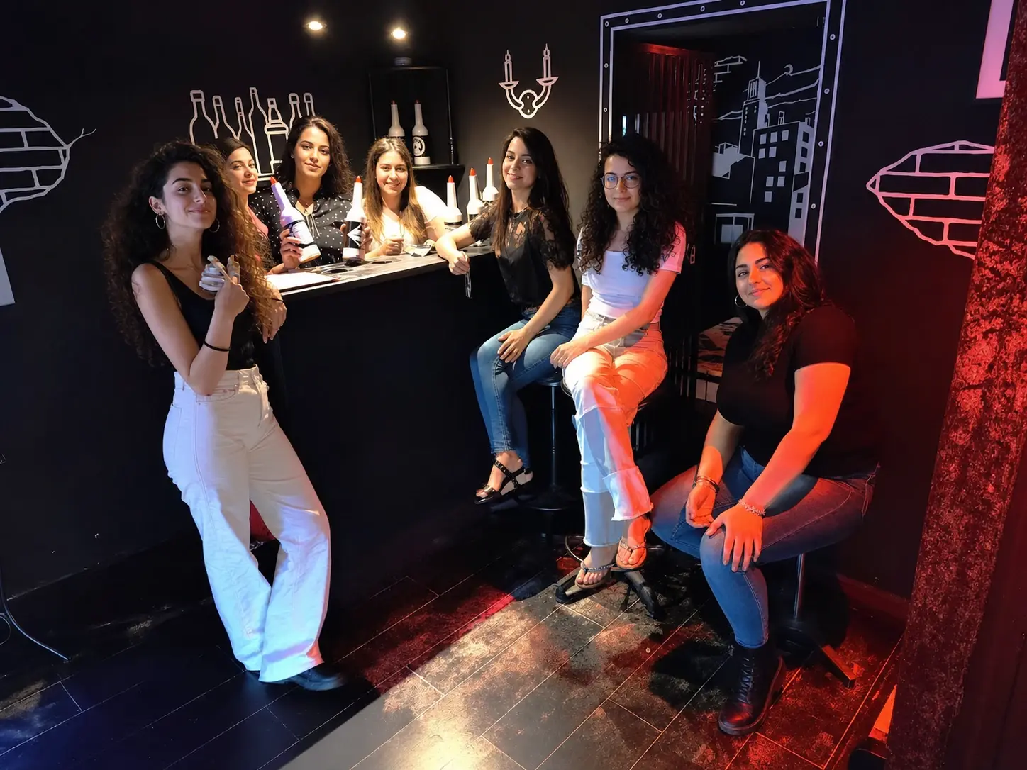קבוצת חברות מצטלמת באזור המשחק המואר בניאון