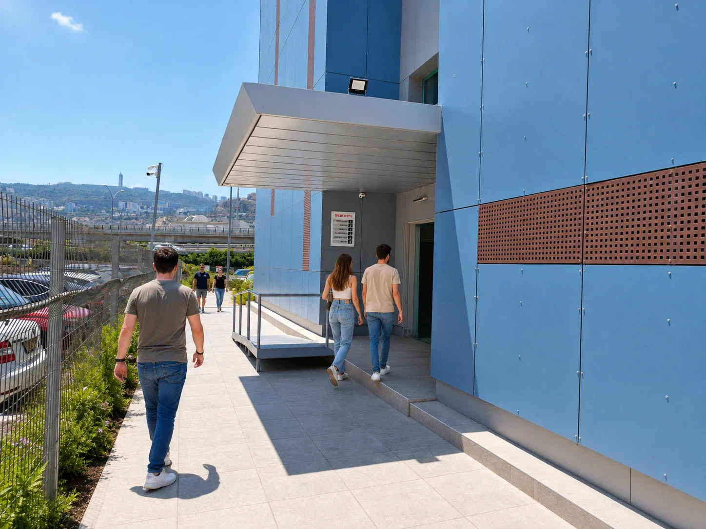 שביל לצד הבניין הכחול המוביל אל דלת הכניסה של בית טופר