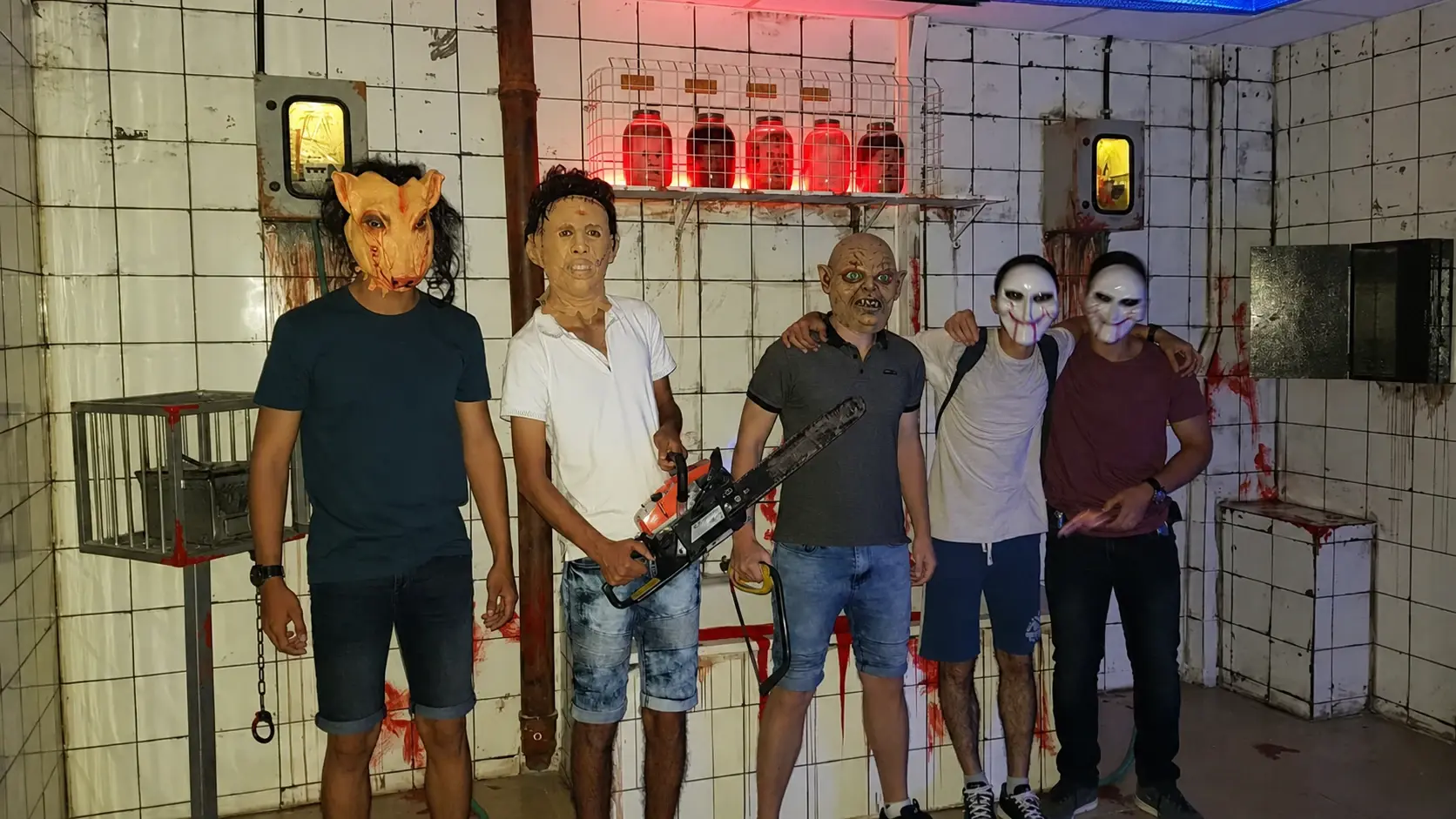 קבוצה עם דמויות אימה רעולות פנים בחדר המסור